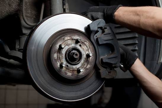 Mechanic fitting brake pads onto a brake disc