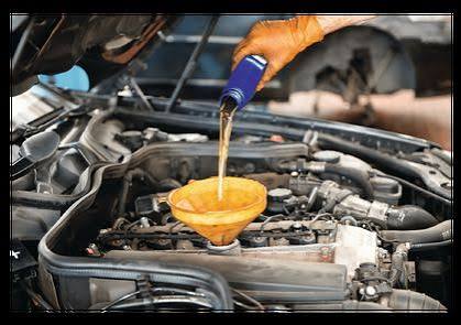 Engine oil being poured through a funnel during an oil change