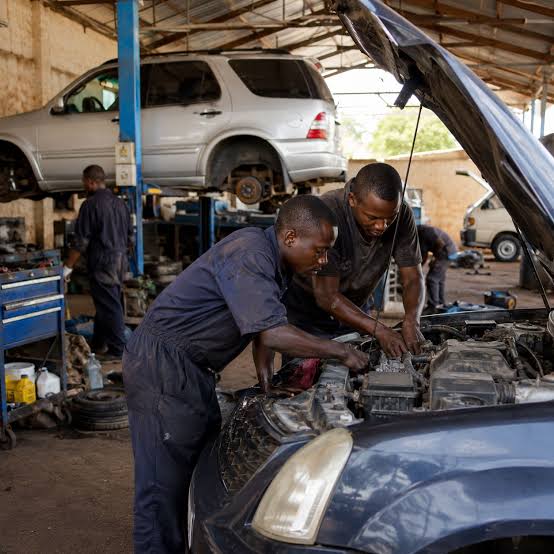 Glambo Garage mechanics working together on a car engine